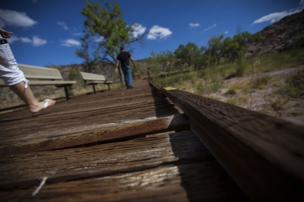 Part of a wooden plank sticks up from the boardwalk as people walk by at the Red Springs picnic area in the Red Rock Canyon National Conservation Area on Tuesday, July 21, 2015. A portion of the b ...