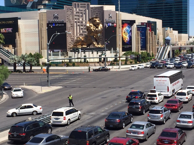 An officer directs traffic at Tropicana Avenue and the Las Vegas Strip on Saturday, July 25, 2015. A fire at The Cosmopolitan of Las Vegas has closed the Strip from Tropicana to Flamingo Road.(Cha ...
