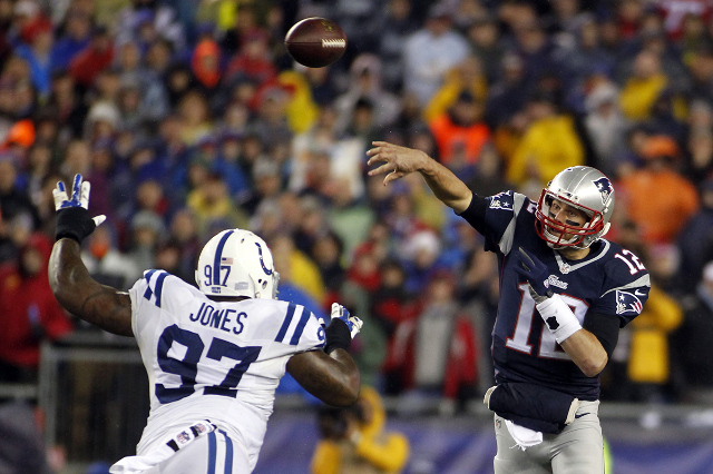 Jan 18, 2015; Foxborough, MA, USA; New England Patriots quarterback Tom Brady (12) passes the ball over Indianapolis Colts defensive end Arthur Jones (97) during the first quarter in the AFC Champ ...