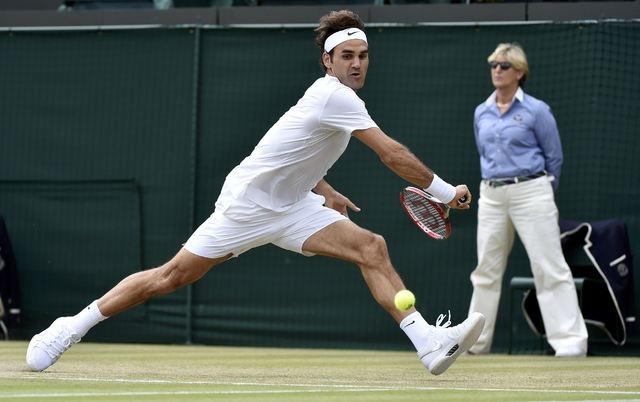 Roger Federer of Switzerland hits a shot during his match against Gilles Simon of France at the Wimbledon Tennis Championships in London, July 8, 2015. (REUTERS/Toby Melville)