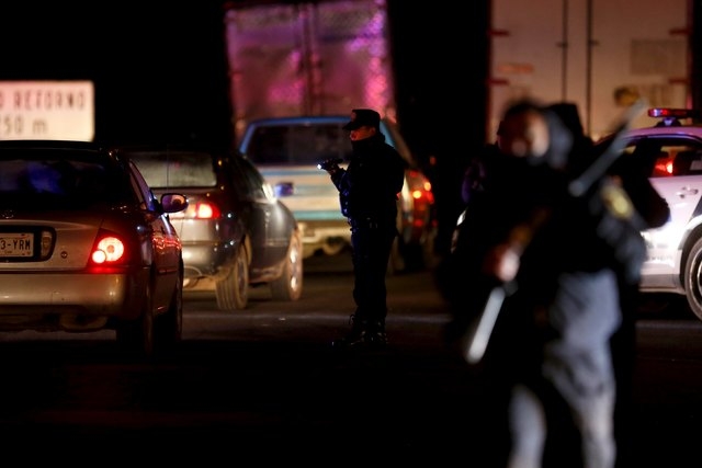 Policemen inspect vehicles at a checkpoint outside the Altiplano Federal Penitentiary, after drug lord Joaquin 'El Chapo' Guzman escaped, in Almoloya de Juarez, on the outskirts of Mexico City, Ju ...