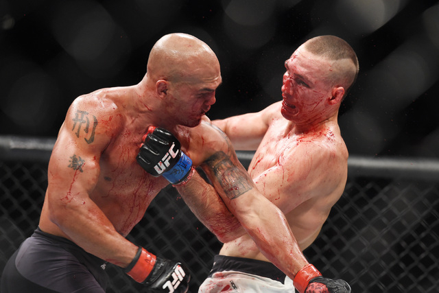 Robbie Lawler, left, and Rory Macdonald trade punches in their welterweight title fight at UFC 189 Saturday, July 11, 2015 at the MGM Grand Garden Arena in Las Vegas, Nevada. Lawler won by TKO in ...