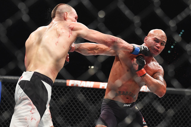 Robbie Lawler, right, and Rory Macdonald trade punches in their welterweight title fight at UFC 189 Saturday, July 11, 2015 at the MGM Grand Garden Arena in Las Vegas, Nevada. Lawler won by TKO in ...