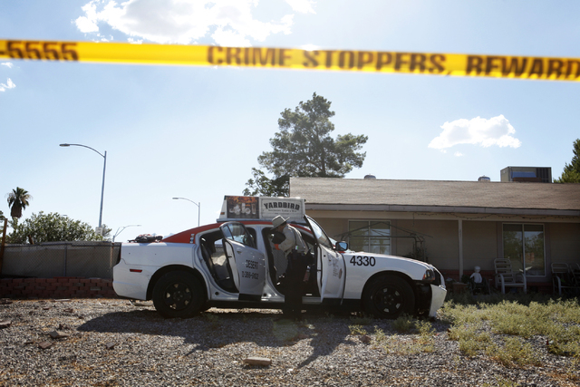 An officer investigates the inside of a stolen cab on Wednesday, July 8, 2015 in Henderson. A man who robbed a bank took a cab and crashed it off West Alexander Road and Torrey Pines Drive. (James ...