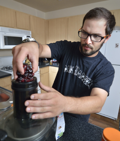 John Brownie adds frozen berries to a juicer at his home in Las Vegas on Tuesday, June 30, 2015. Dietary changes such as cutting dairy products have helped him get a case of irritable bowel syndro ...