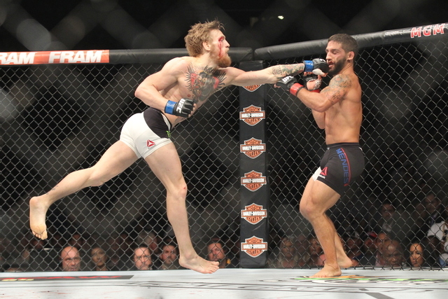 Conor McGregor, left, throws a jab at Chad Mendes in their interim featherweight title bout at UFC 189 at the MGM Grand Garden Arena Saturday, July 11, 2015, in Las Vegas. McGregor won by knockout ...