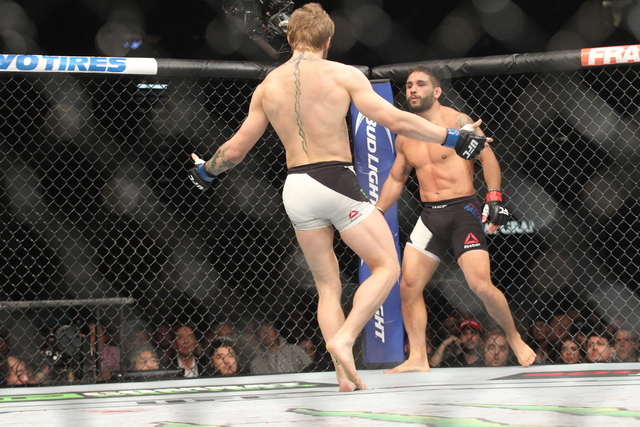 Conor McGregor, left, taunts Chad Mendes during their interim featherweight title bout at UFC 189 at the MGM Grand Garden Arena Saturday, July 11, 2015, in Las Vegas. McGregor won by knockout. (Ch ...