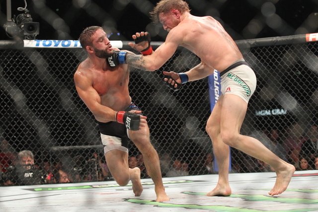 Conor McGregor, right, lands a left jab on Chad Mendes during their interim featherweight title bout at UFC 189 at the MGM Grand Garden Arena Saturday, July 11, 2015, in Las Vegas. McGregor won by ...