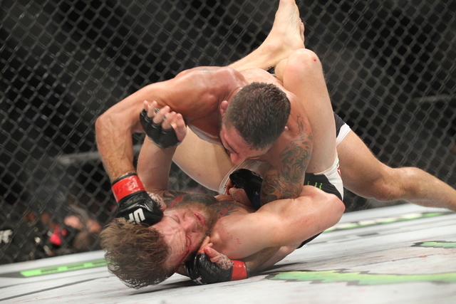 Chad Mendes, above, lands a hard jab against Conor McGregor during their interim featherweight title bout at UFC 189 at the MGM Grand Garden Arena Saturday, July 11, 2015, in Las Vegas. McGregor w ...