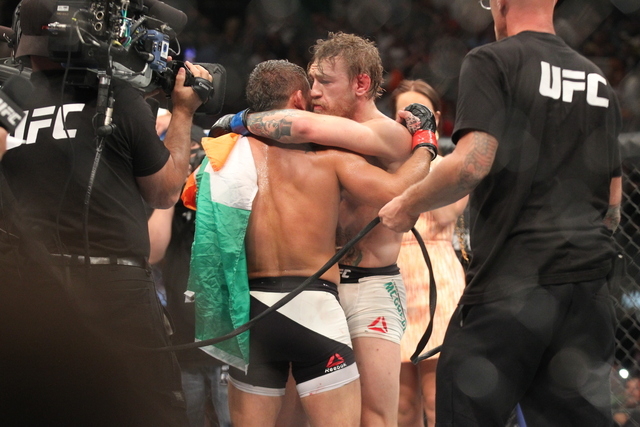Conor McGregor, right, hugs Chad Mendes after defeating Mendes in their interim featherweight title bout at UFC 189 at the MGM Grand Garden Arena Saturday, July 11, 2015, in Las Vegas. McGregor wo ...