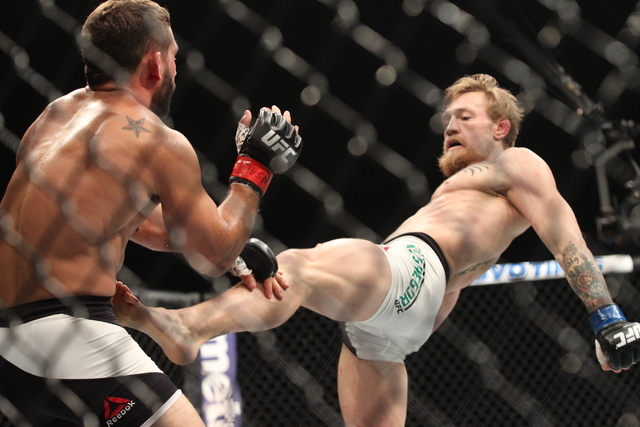 Conor McGregor, right, kicks Chad Mendes during their interim featherweight title bout at UFC 189 at the MGM Grand Garden Arena Saturday, July 11, 2015, in Las Vegas. McGregor won by knockout. (Ch ...