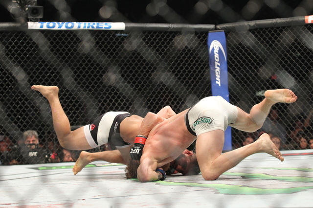 Chad Mendes, left, and Conor McGregor grapple during their interim featherweight title bout at UFC 189 at the MGM Grand Garden Arena Saturday, July 11, 2015, in Las Vegas. McGregor won by knockout ...