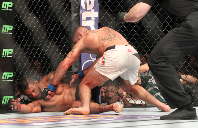Jeremy Stephens, right, throws a left jab after knocking down Dennis Bermudez during UFC 189 at the MGM Grand Garden Arena Saturday, July 11, 2015, in Las Vegas. Stephens won by knockout. (Chase S ...