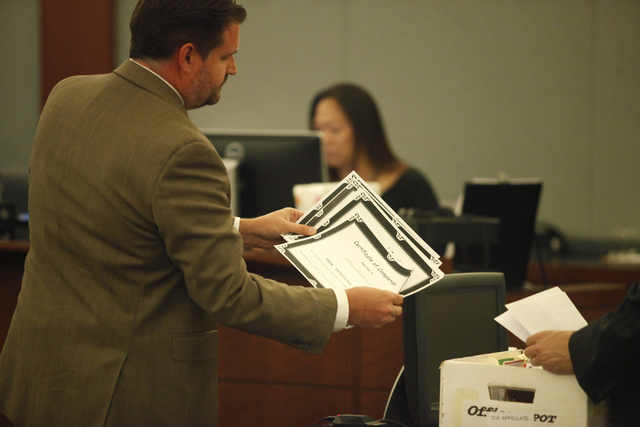 Paul Herron's lawyer Daniel Page shows Herron's course completion certificates to the plaintiff in Judge Michael Villani's court on Thursday, June 4, 2015, in Las Vegas.  Herron, who was sentenced ...