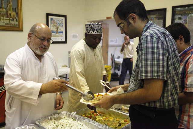 Amanullah Naqshband, left, serves food for members of the Islamic Society of Nevada on Sunday, July 5, 2015 in Las Vegas. During Ramadan some Muslims do not eat or drink during the day. (James Ten ...