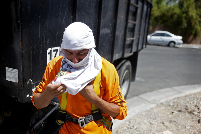 Carlos Salseda of Adaven Homes uses a shirt to mask his face and neck while he does construction work on Wednesday, July 1, 2015, in North Las Vegas. This past June was the hottest on record. (Jam ...