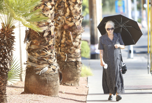 A woman holds her umbrella to protect herself from sun as she walks near Bonanza Road and Bruce Street on Friday, July 10, 2015.(Bizuayehu Tesfaye/Las Vegas Review-Journal) Follow Bizu Tesfaye on ...
