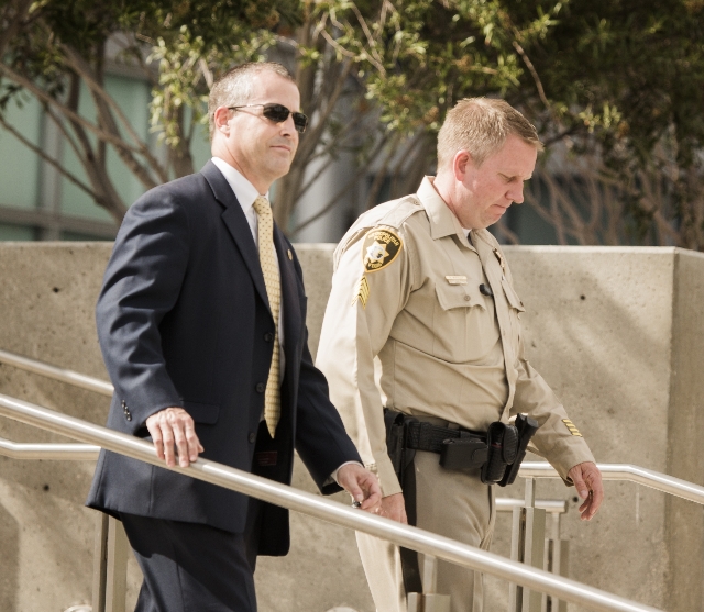 FBI Agent Michael Elliott ,left, and  Las Vegas police Sgt. Robert Whiteley, lead investigators in the HOA fraud case, walk down the steps of the Lloyd D. George U.S. Courthouse on Thursday, Aug.  ...