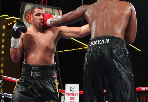 Derric Rossy, left, takes a hit from Trevor Bryan during their NABF heavyweight title fight Friday at the Downtown Las Vegas Events Center. Bryan (16-0) won a 10-round unanimous decision. CHASE ST ...