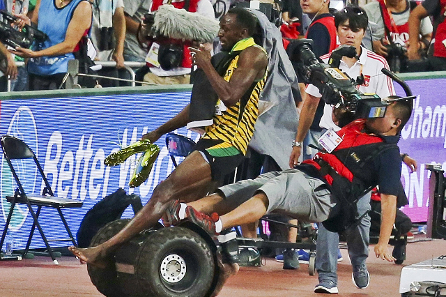 Usain Bolt of Jamaica is hit by a cameraman on a Segway as he celebrates after winning the men‘s 200 metres final at the 15th IAAF World Championships at the National Stadium in Beijing, Chi ...