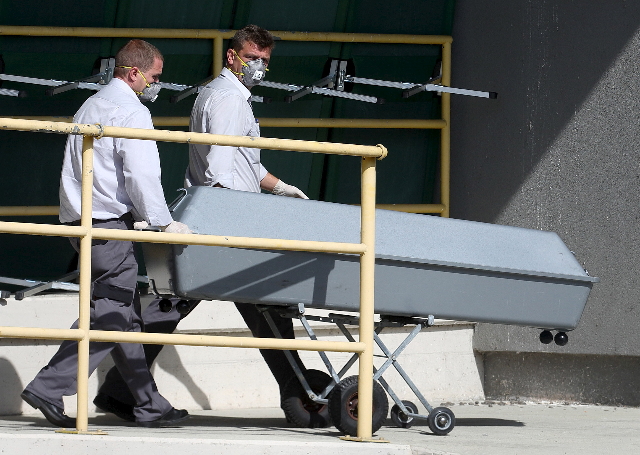 A coffin is rolled onto a truck at a customs building with refrigeration facilities in the village of Nickelsdorf, Austria, August 28, 2015. A truck full of refugees discovered abandoned on an Aus ...