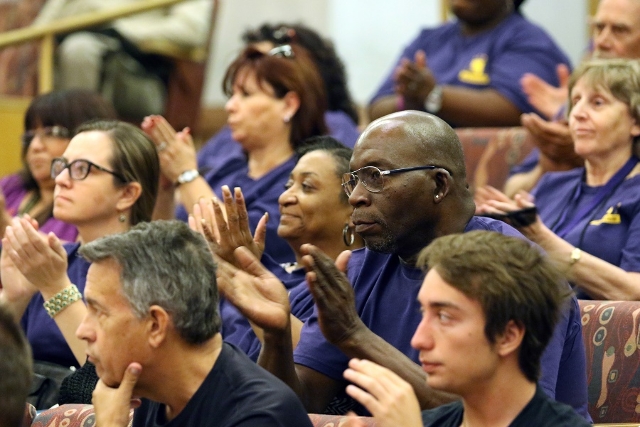 Service Employees International Union Local 1107 members and supporters wearing purple shirts show their support after SEIU Local 1107 President Martin Bassick speaks during public comment at the  ...