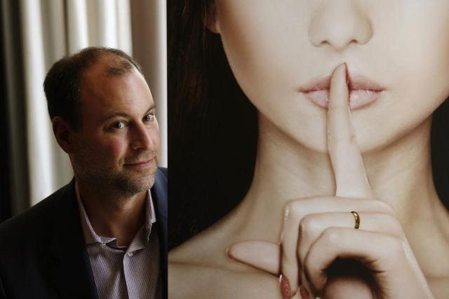 Ashley Madison founder Noel Biderman poses with a poster during an interview at a hotel in Hong Kong, Aug. 28, 2013. (Bobby Yip/Reuters)