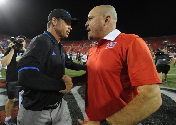 UCLA Bruins head coach Jim Mora, left, and UNLV Rebels head coach Tony Sanchez shake hands at the conclusion of their NCAA Football game at Sam Boyd Stadium Saturday, Sept. 12 2015. UCLA defeated  ...