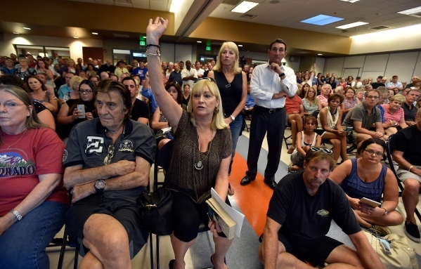 Resident Maureen Hasson, center, raises her hand to ask a question during a homeowners association meeting for the Silverstone golf course community at the Centennial Hills YMCA in Las Vegas on Tu ...