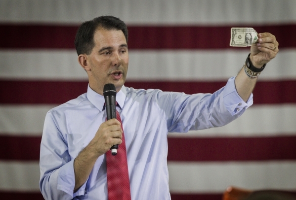 Republican presidential candidate Wisconsin Gov. Scott Walker holds a dollar while speaking during a town hall at XTreme Manufacturing Warehouse,1415 West Bonanza Road, on Monday, Sept. 14, 2015JE ...