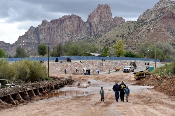 Residents walk across one of the many flooded streets after a flash flood in Hildale, Utah September 15, 2015. Flash floods killed nine people near Utah‘s border with Arizona when a "la ...