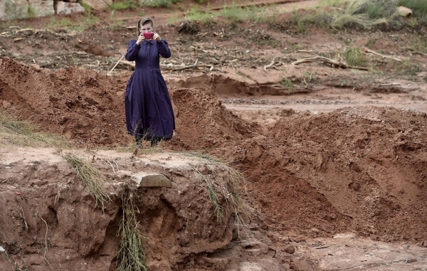 A resident takes pictures of an estimated 50-foot deep gorge that was created after a flash flood in Hildale, Utah September 15, 2015. At least eight people were killed near Utah‘s border wi ...