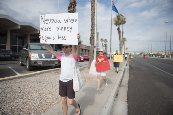 Clark County School District teachers Andy Lotte, left, and Shannon Hale picket with fellow teachers outside of the district‘s Edward Greer Education Center in Las Vegas on Thursday, July 2, ...