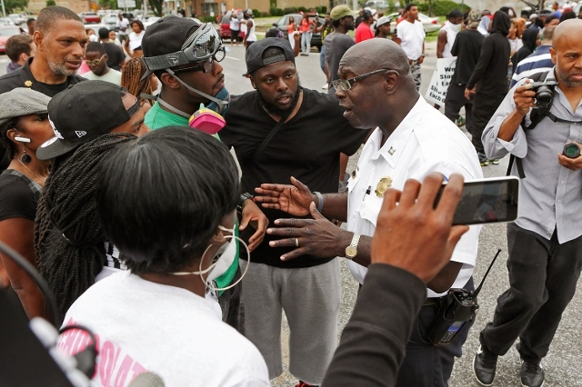 Police and residents talk after a shooting incident in St. Louis, Missouri August 19, 2015. Police fatally shot a black man they say pointed a gun at them, drawing angry crowds and recalling the r ...
