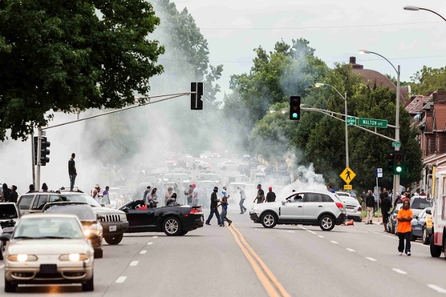 Smoke rises as police attempt to disperse protesters on Page  Ave. after a shooting incident in St. Louis, Missouri August 19, 2015. Police fatally shot a black man they say pointed a gun at them, ...