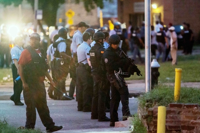 Police line up to block the street as protesters gathered after a shooting incident in St. Louis, Missouri August 19, 2015. Police fatally shot a black man they say pointed a gun at them, drawing  ...