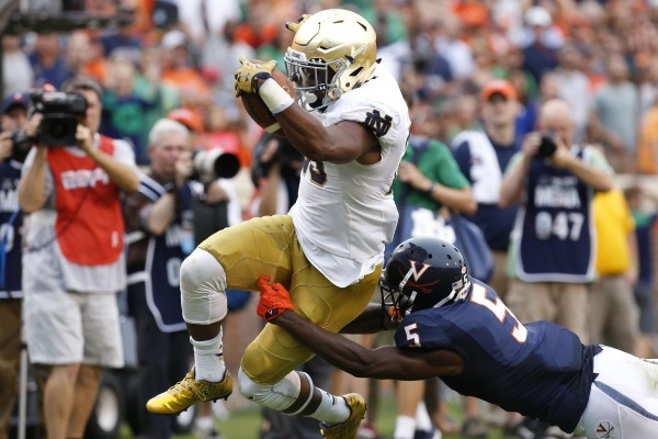 Sep 12, 2015; Charlottesville, VA, USA; Notre Dame Fighting Irish wide receiver C.J. Prosise (20) carries the ball for a touchdown as Virginia Cavaliers cornerback Tim Harris (5) attempts to make  ...