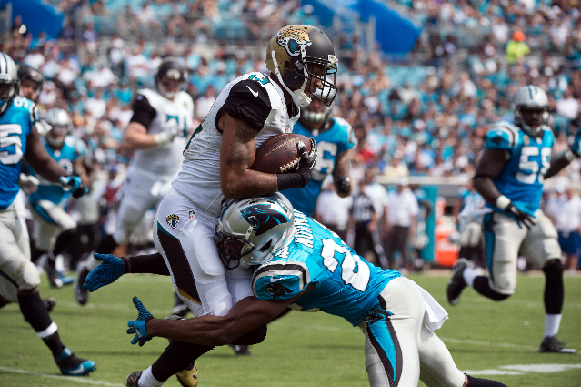 Sep 13, 2015; Jacksonville, FL, USA; Jacksonville Jaguars wide receiver Rashad Greene (13) is tackled by Carolina Panthers cornerback Josh Norman (24) during the second half at EverBank Field. The ...