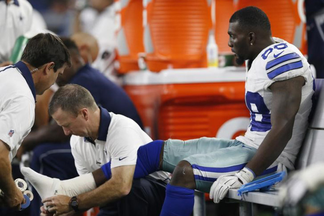 Sep 13, 2015; Arlington, TX, USA; Dallas Cowboys receiver Dez Bryant (88) gets his right ankle worked on by trainers while on the bench in the fourth quarter against the New York Giants at AT& ...