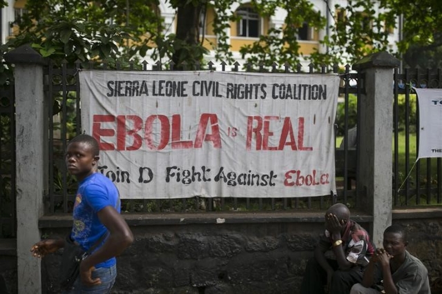 A man walks past a banner about Ebola in Freetown, Sierra Leone, Dec. 16, 2014. (Baz Ratner/Reuters)
