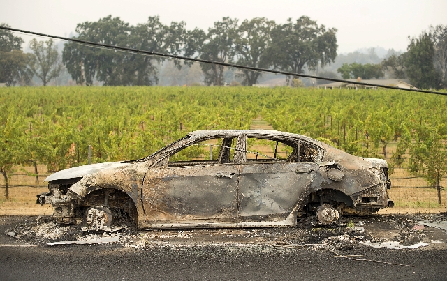 A burned out car sits in front of a vineyard following the Valley Fire near Middleton, California September 14, 2015. At least 400 homes and hundreds of other buildings have gone up in flames and  ...