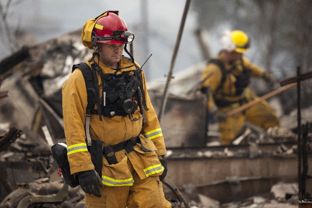 Firefighters search for victims in the rubble of a home burnt by the Valley Fire in Middletown, California, September 14, 2015. REUTERS/David Ryder