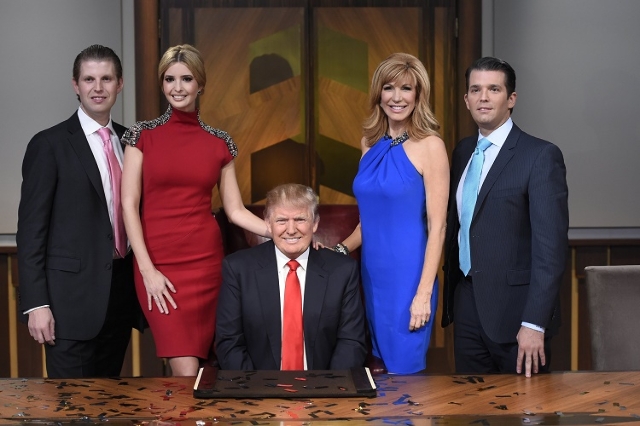 Ivanka Trump (red dress) with Eric Trump (left) and Donald Trump (sitting) (Reuters/David Giesbrecht/NBC)