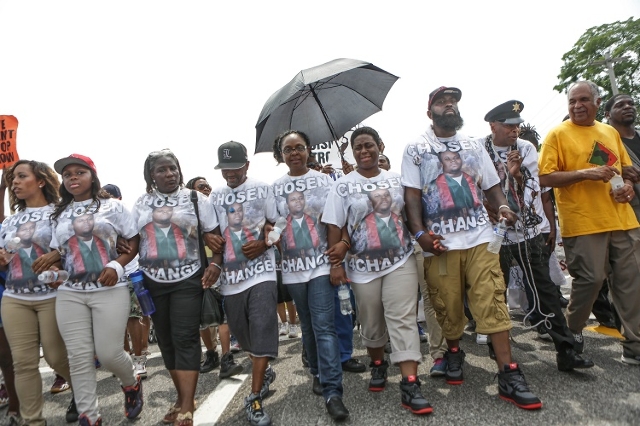 Members of the community, including family members of the late Michael Brown, join together on August 9, 2015, for a march through Ferguson, Missouri, including a stop at the memorial for Michael  ...