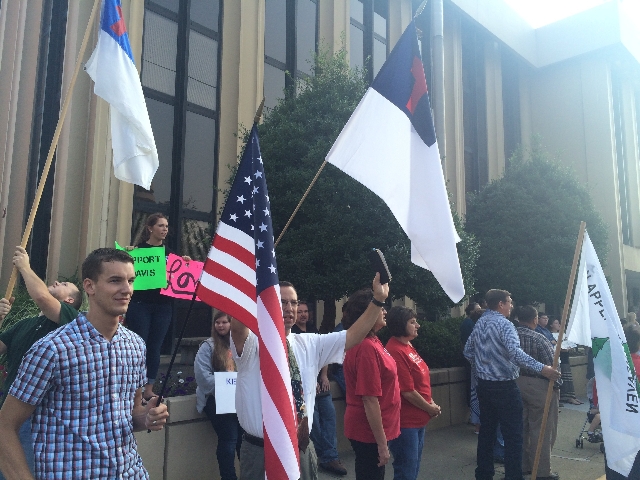 Supporters hold signs and flags outside federal court in Ashland, Kentucky, on Thursday, Sept. 3, 2015. Rowan County Clerk Kim Davis was held in contempt of court after she refused a Supreme Court ...