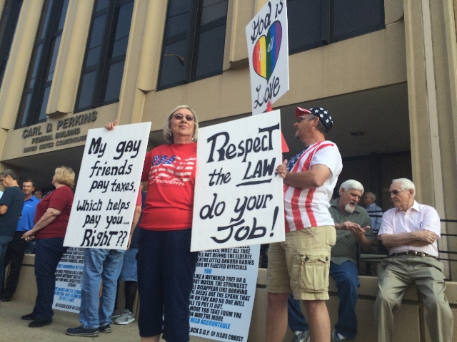Supporters hold signs and flags outside federal court in Ashland, Kentucky, on Thursday, Sept. 3, 2015. Rowan County Clerk Kim Davis was held in contempt of court after she refused a Supreme Court ...