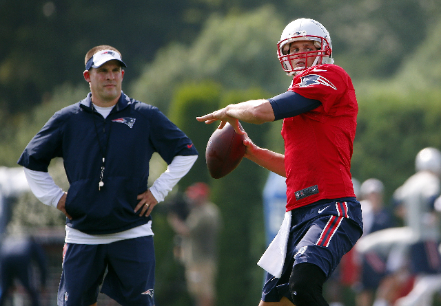 Jul 30, 2015; Foxborough, MA, USA; New England Patriots quarterback Tom Brady (12) throws as offensive coordinator Josh McDaniels looks on during training camp at Gillette Stadium. (Winslow Townso ...