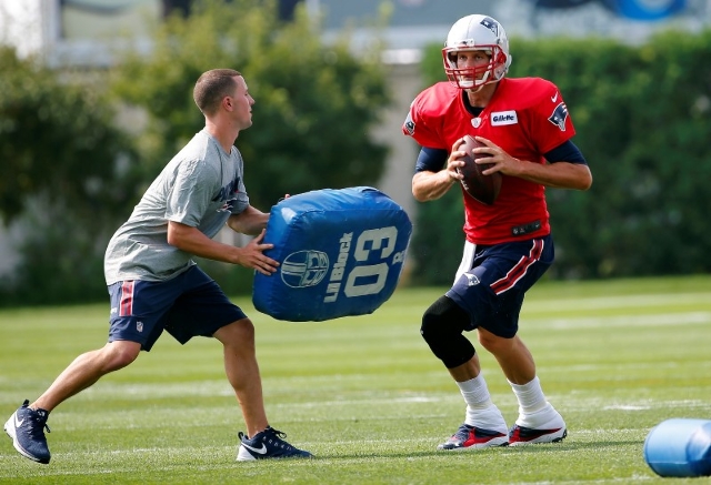 Jul 30, 2015; Foxborough, MA, USA; New England Patriots quarterback Tom Brady (12) avoids a blocker during training camp at Gillette Stadium. (Winslow Townson/USA Today Sports)