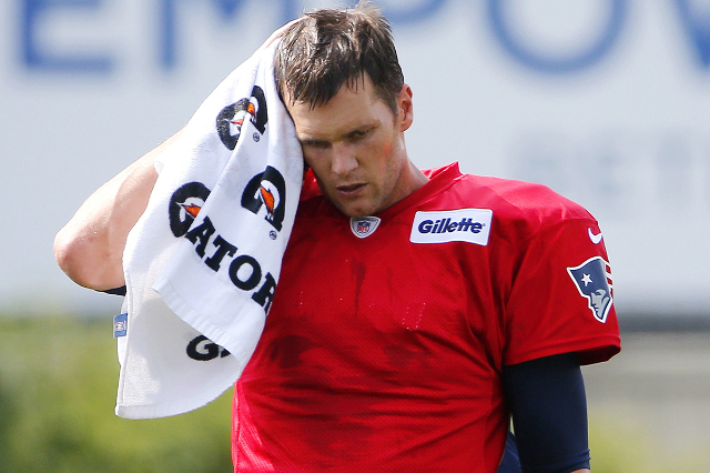 Jul 30, 2015; Foxborough, MA, USA; New England Patriots quarterback Tom Brady (12) wipes away sweat during training camp at Gillette Stadium. (Winslow Townson/USA Today Sports)