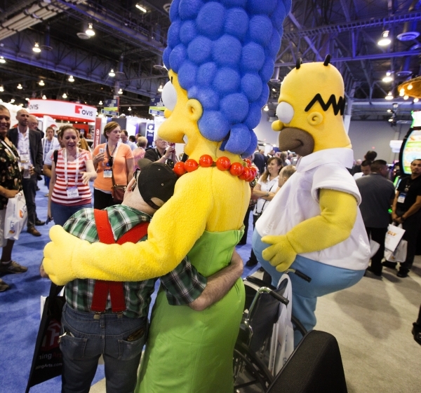 Joe Manee hugs a Marge Simpson character at the Simpson-themed slots at Scientific Games booth during the Global Gaming Expo at the  Sands Expo and Convention Center on Tuesday, Sept. 29,2015. (Je ...